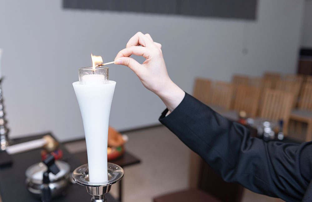 葬儀式場の蝋燭に点火する様子